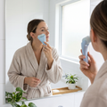 Person using a cooling facial ice roller on their cheek