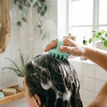 Person using a silicone scalp massager brush while washing hair