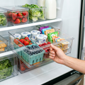 Person pulling out a clear fridge organizer drawer