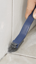 Person using 2-in-1 Corner Cleaning Brush in a realistic lifestyle scene