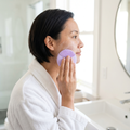 Person washing their face with a silicone cleansing brush