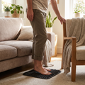 Person standing on a textured foot massage mat