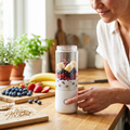 Person blending fruit in a portable blender cup