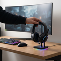 Person placing a gaming headset on an RGB headset stand